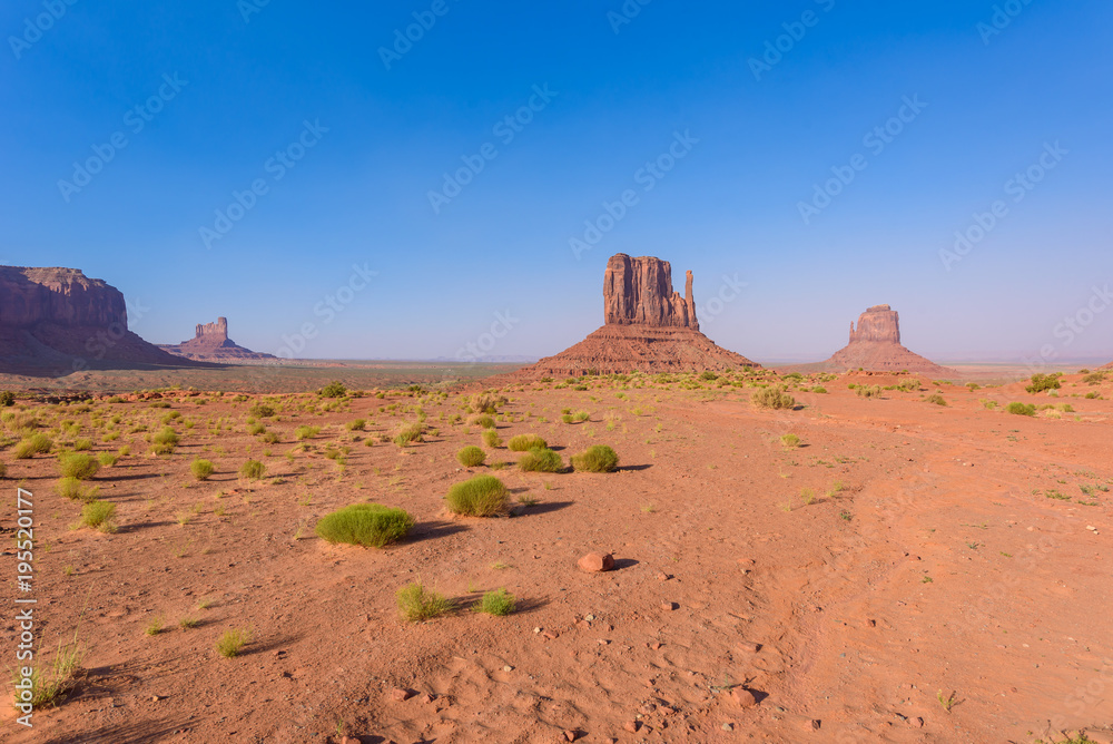 Fototapeta premium Scenic Drive on Dirt Road through Monument Valley, The famous Buttes of Navajo tribal Park, Utah - Arizona, USA. Scenic road and red rock formations.