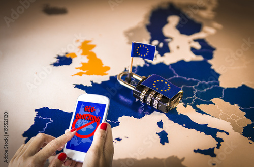 Female hands using a smartphone with geoblocking on screen and Padlock over EU map. European Union Digital single market and regulation against Geo-blocking and geographically-based restrictions photo