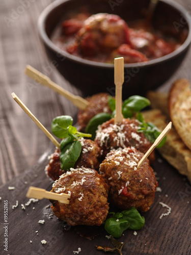 Delicious homemade meat balls with tomato sauce on skewers.