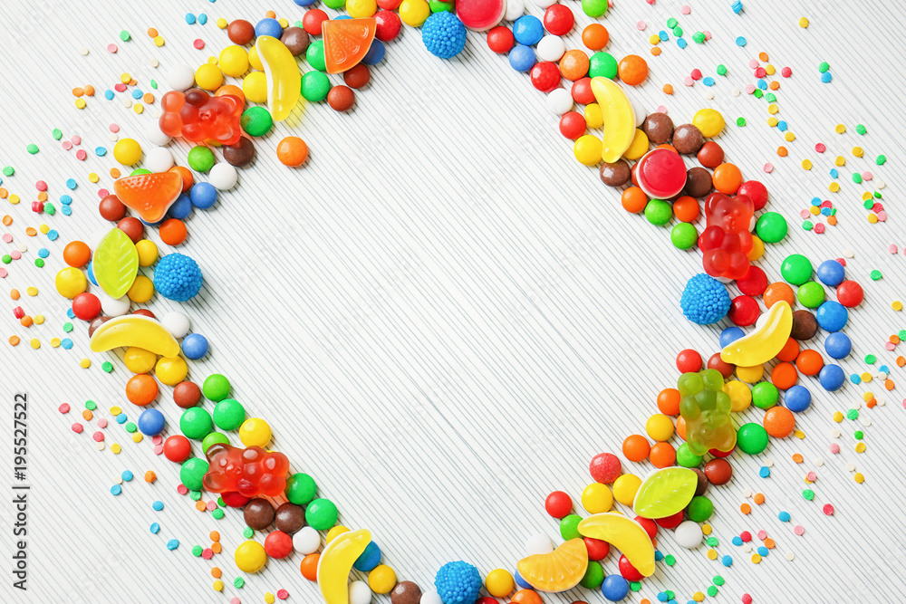 Frame of colorful candies on light background