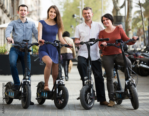 Young and mature couples staying with bikes outdoor