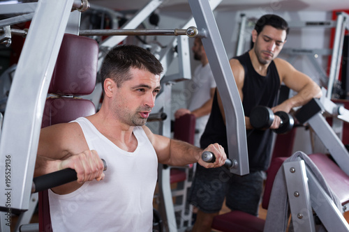 Man training on fitness machine in gym
