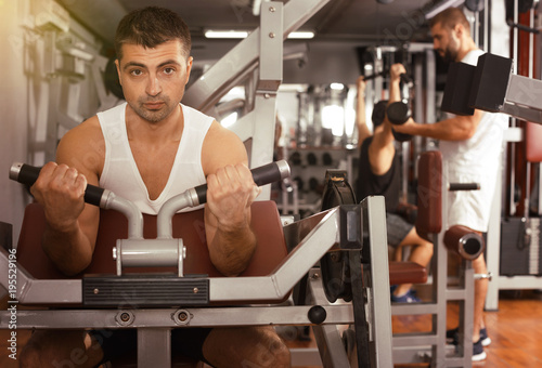 Man training on fitness machine in gym