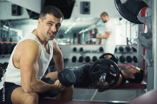 Man doing exercises with dumbbells at gym