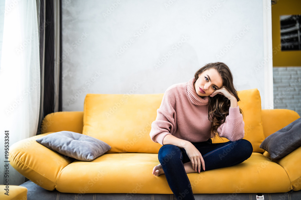 Picture of a tired unkempt woman sitting on he couch at home. Girl watch TV  new