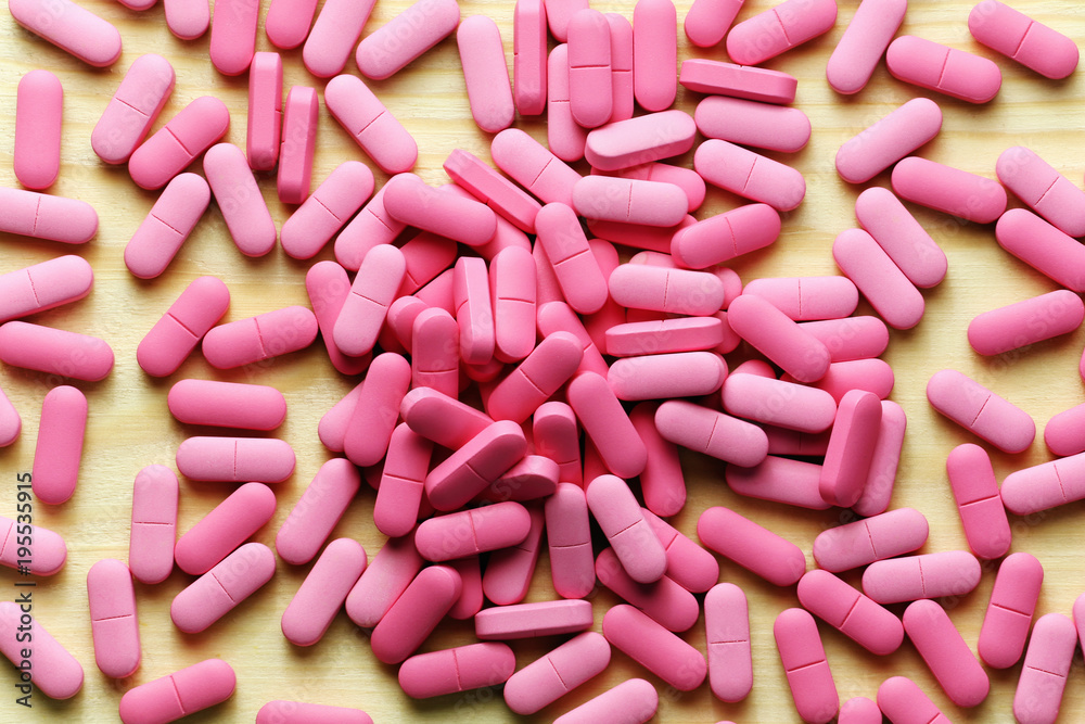 Pink medicine pills on a wood background Pink medicine pills on a wood background