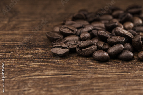 Texture of coffee beans on a wooden background close-up.