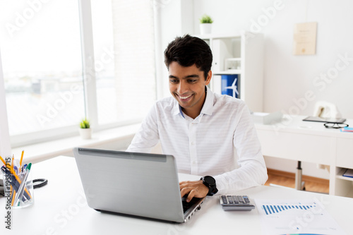 businessman with laptop and papers at office