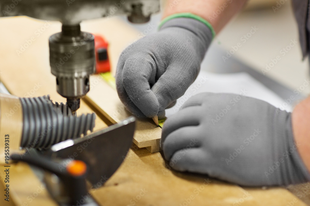 carpenter with ruler measuring board at workshop