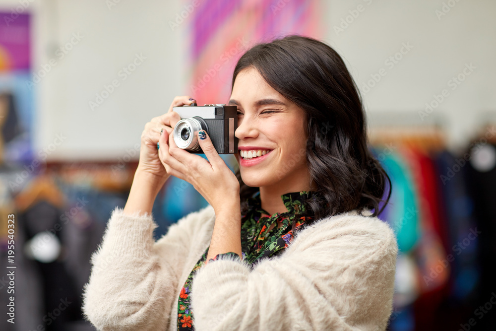 smiling woman photographing by vintage film camera