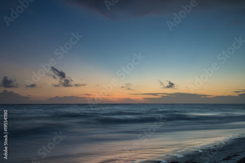 A long exposure of the sea at golden hour, as dawn starts to break over a white sandy beach. © Rob Thorley