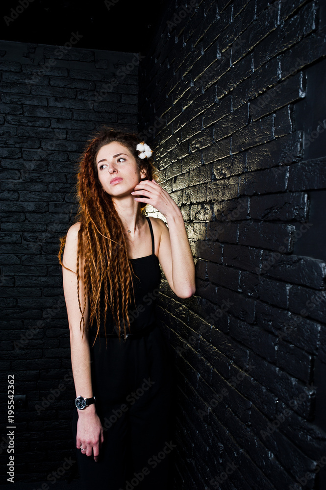 Studio shoot of girl in black with dreads on brick background. Studio shoot of girl in black with dreads on brick background.