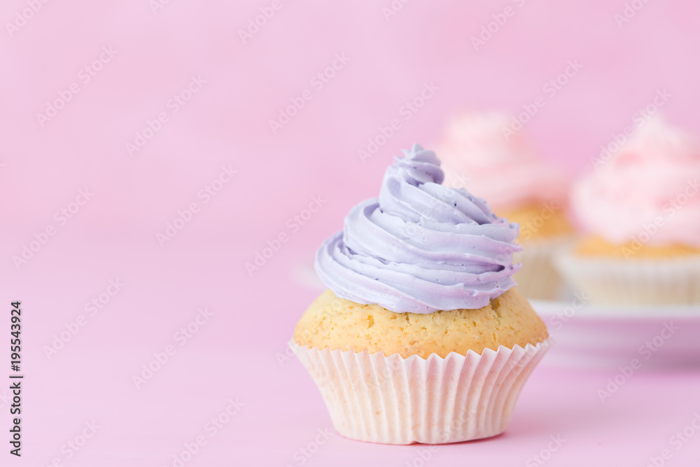 Cupcake decorated with pink and violet buttercream on pastel pink background. Sweet beautiful cake. Horizontal banner, greeting card for birthday, wedding. Close up photography. Selective focus Cupcake decorated with pink and violet buttercream on pastel pink background. Sweet beautiful cake. Horizontal banner, greeting card for birthday, wedding. Close up photography. Selective focus