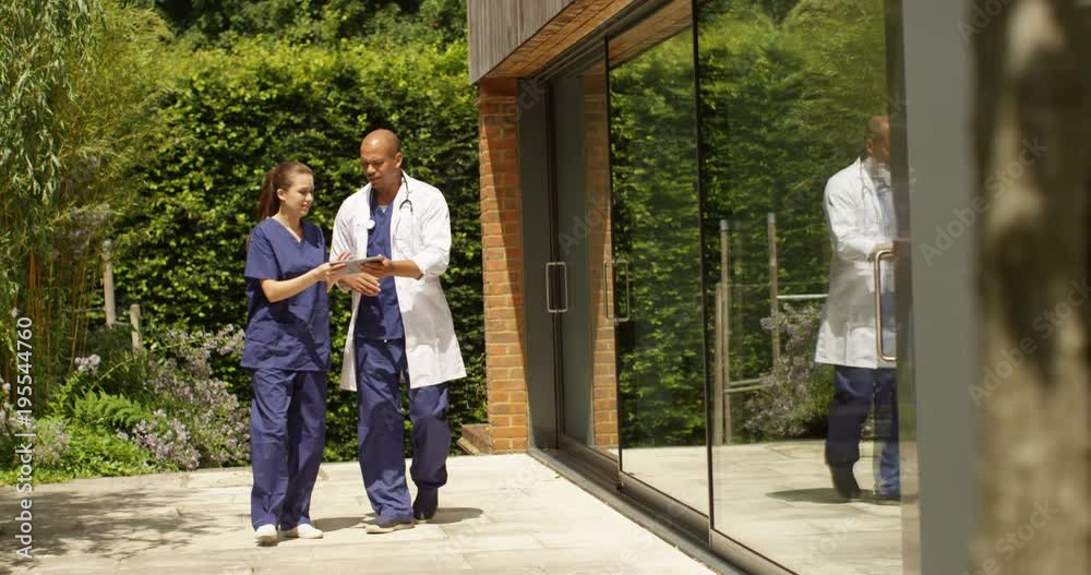 4K Medical workers having a disagreement outdoors about notes on a digital tablet. Slow motion