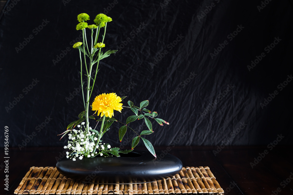 Japanese style flower arrangement ikebana on bamboo mat. Stock Photo |  Adobe Stock