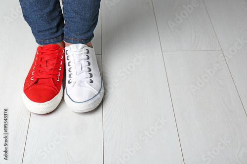 Woman in different sneakers indoors photo
