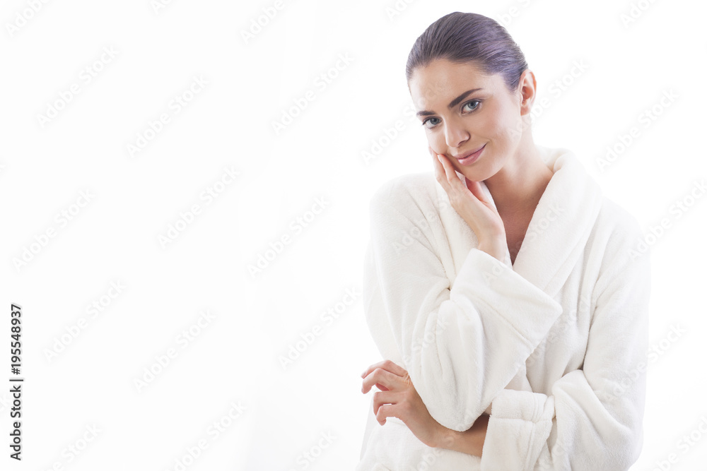 Beautiful and natural woman in white bathrobe is touching her skin. Relax and comfortable feelings only. Beautiful and natural woman in white bathrobe is touching her skin. Relax and comfortable feelings only.