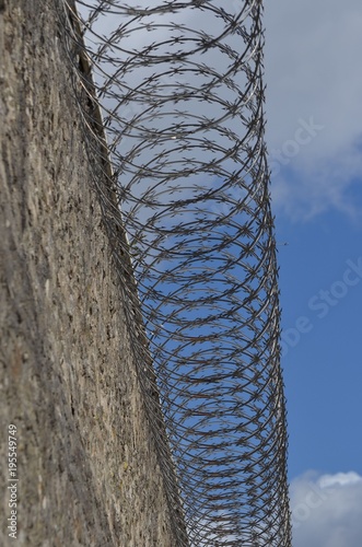 Mur de prison avec barbelés au sommet photo