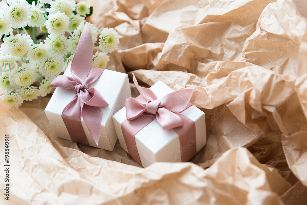 White gift boxes of the famous jewelry brand with charms bracelets with a pink ribbon. Mock up. Empty place for an inscription. Postcard for the holiday. White gift boxes of the famous jewelry brand with charms bracelets with a pink ribbon. Mock up. Empty place for an inscription. Postcard for the holiday.