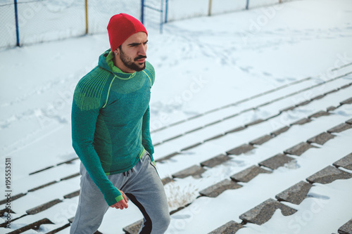 Sportsman walking up the stairs on snowy day