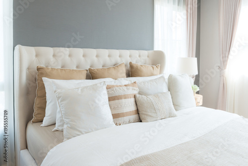 Bedroom in soft light colors. big comfortable double bed in elegant classic bedroom at home. © ake1150