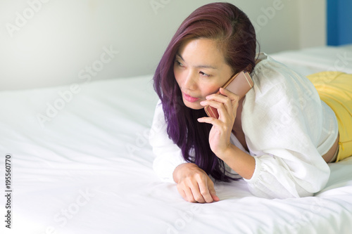 Sexy Woman using a smart phone on bed.