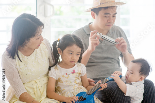 Family playing music instrument at home © WONG SZE FEI