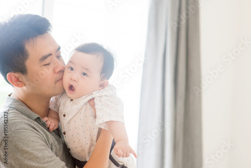 Father kissing baby child.