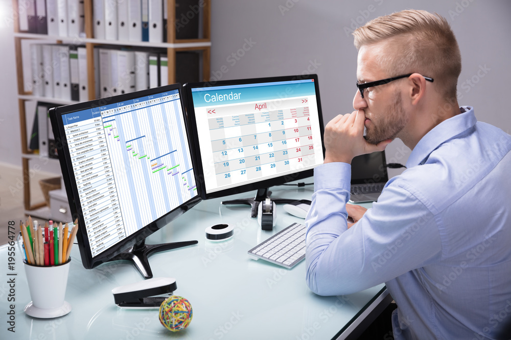 Businessman Looking At Gantt Chart On Computer Businessman Looking At Gantt Chart On Computer