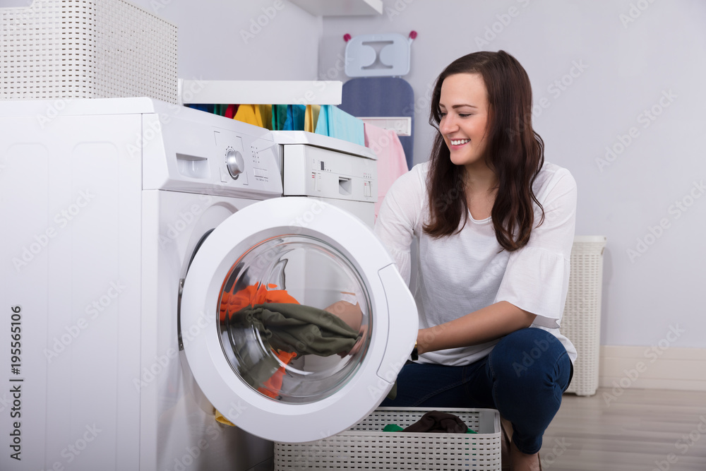 Woman Loading Clothes In Washing Machine Woman Loading Clothes In Washing Machine