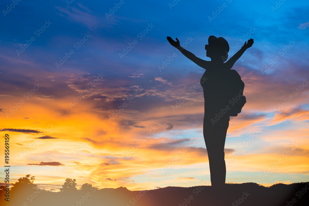 silhouette woman standing and rise hands up at beautiful sunset silhouette woman standing and rise hands up at beautiful sunset