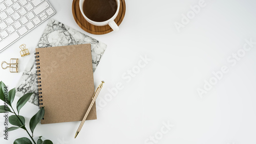 Styled stock photography white office desk table with blank notebook, computer, supplies and coffee cup. Top view with copy space. Flat lay. photo