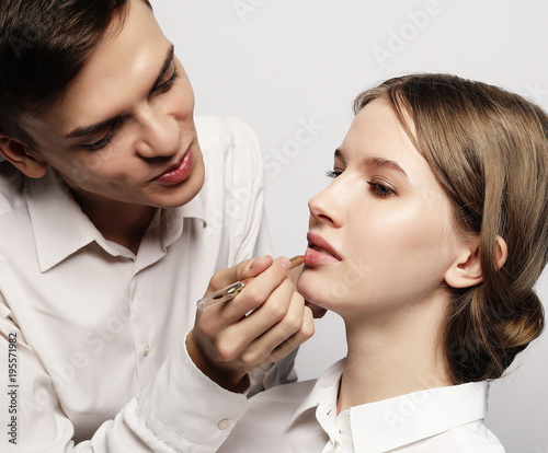 make up artist doing professional make up of young woman