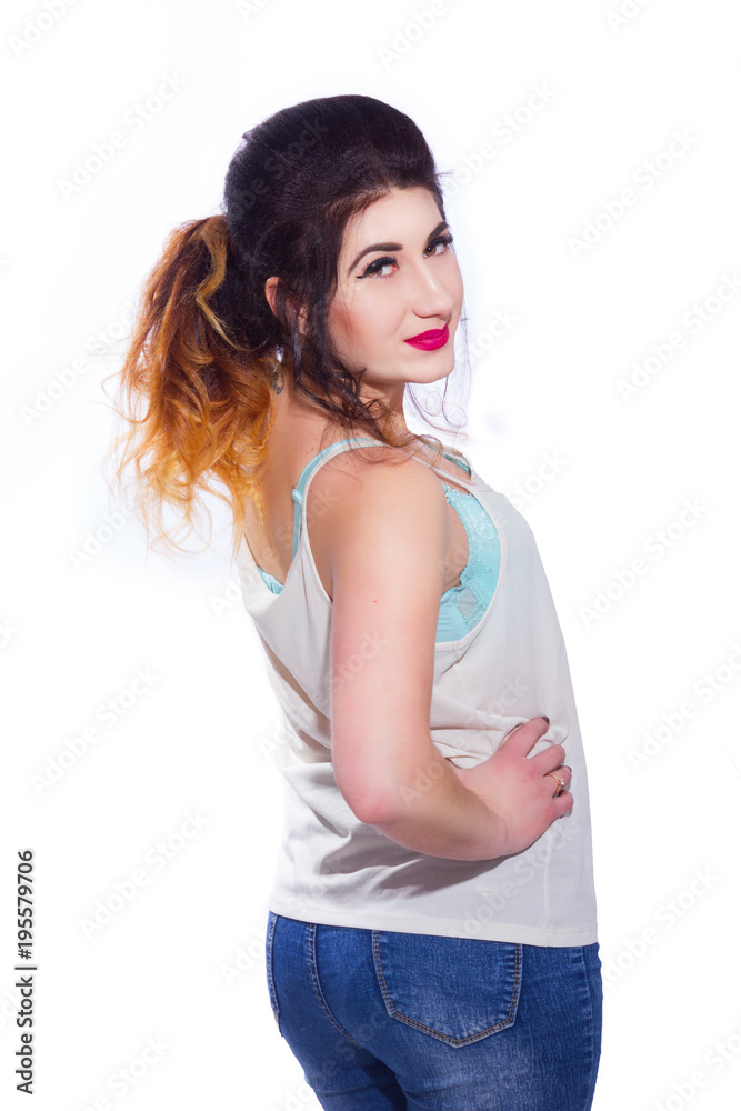 Studio portrait of a beautiful young woman with black hair gathered in a tail. A girl in a T-shirt and jeans poses against a white background. He looks at the camera. Isolate Studio portrait of a beautiful young woman with black hair gathered in a tail. A girl in a T-shirt and jeans poses against a white background. He looks at the camera. Isolate