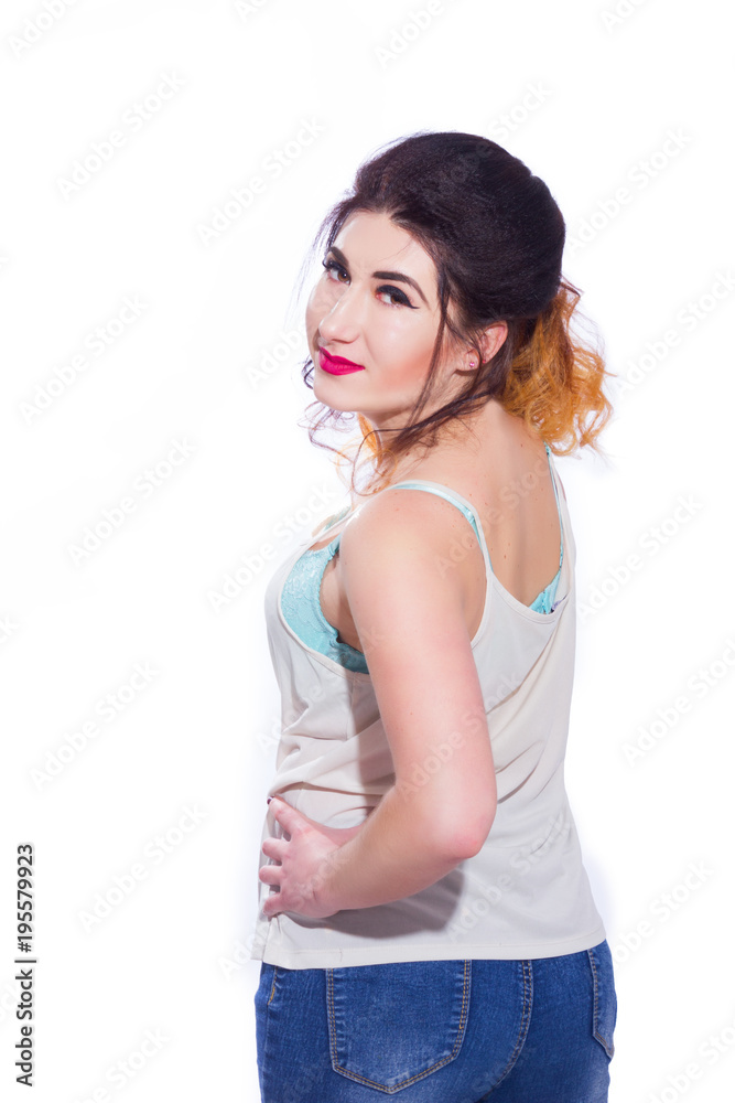 Studio portrait of a beautiful young woman with black hair gathered in a tail. A girl in a T-shirt and jeans poses against a white background. He looks at the camera. Isolate Studio portrait of a beautiful young woman with black hair gathered in a tail. A girl in a T-shirt and jeans poses against a white background. He looks at the camera. Isolate