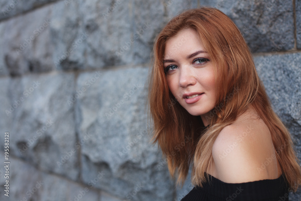 young beautiful red-haired girl looks around.