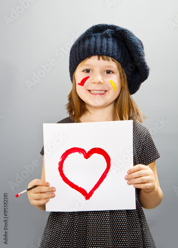 little painter girl with a drwan heart isolated on grey