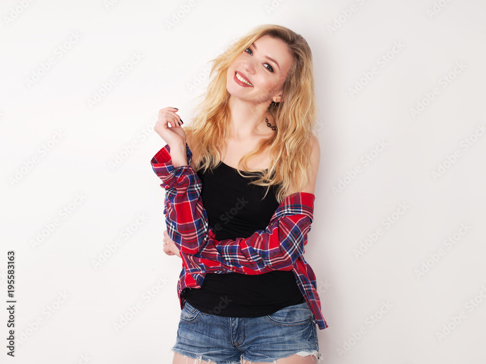 Young beautiful girl posing by the white wall. Young beautiful girl posing by the white wall.