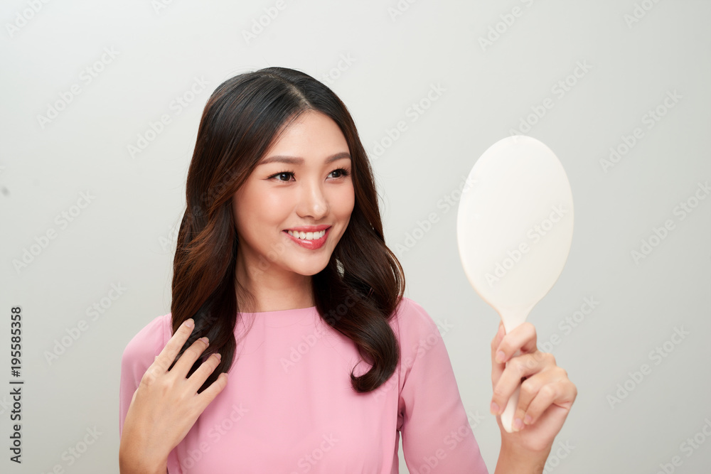 Asian woman looking at the mirror and touching on her skin. Asian woman looking at the mirror and touching on her skin.