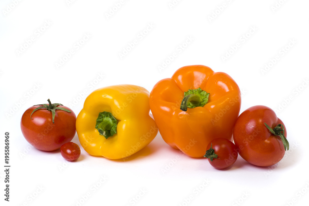 Red yellow and orange peppers with tomatoes on a white background..Multicolored vegetables in a composition on a white background.. Red yellow and orange peppers with tomatoes on a white background..Multicolored vegetables in a composition on a white background..