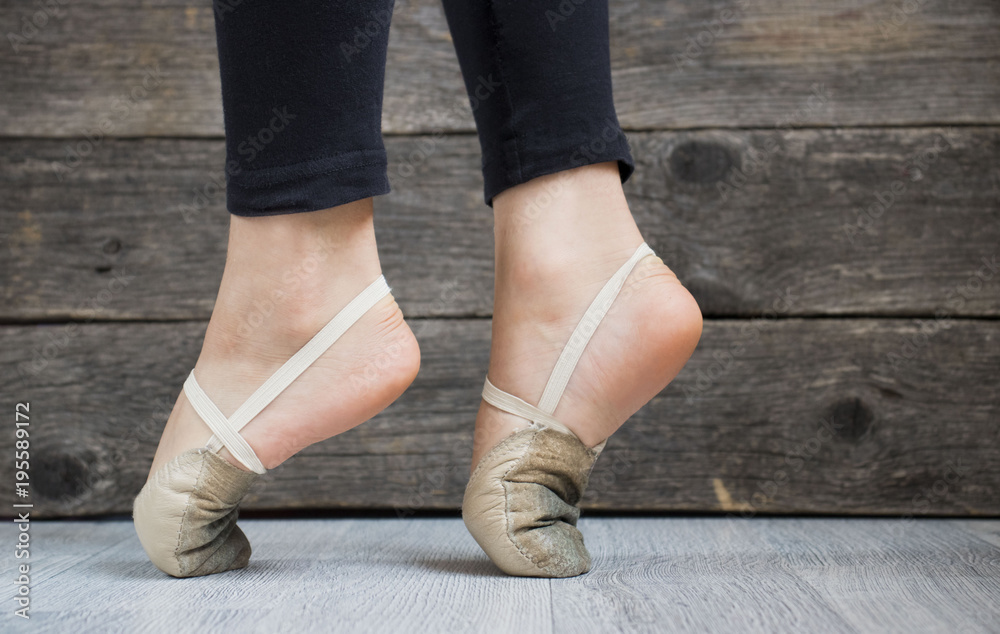 gymnasts feet in the toes on wooden background gymnasts feet in the toes on wooden background