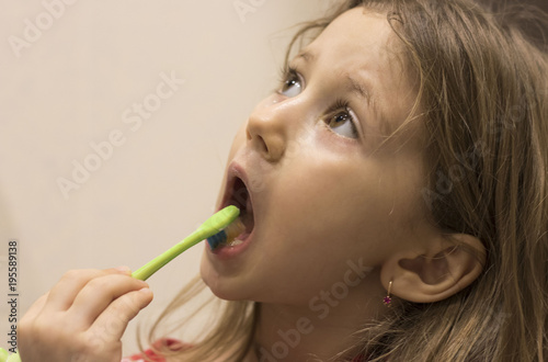 Cute little girl washing her teeth