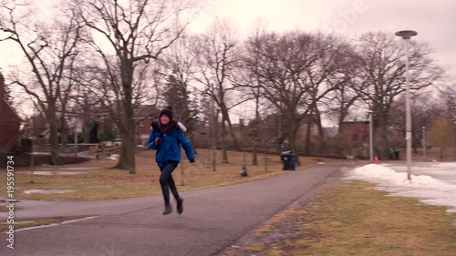 Wallpaper Mural wide shot of a young girl in a wintery park as she runs along the path towards us. Torontodigital.ca