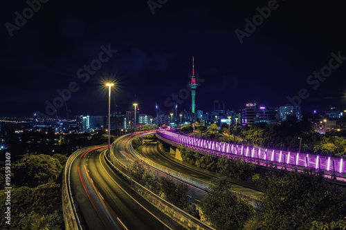 Auckland highway at night and city skyline with Sky Tower