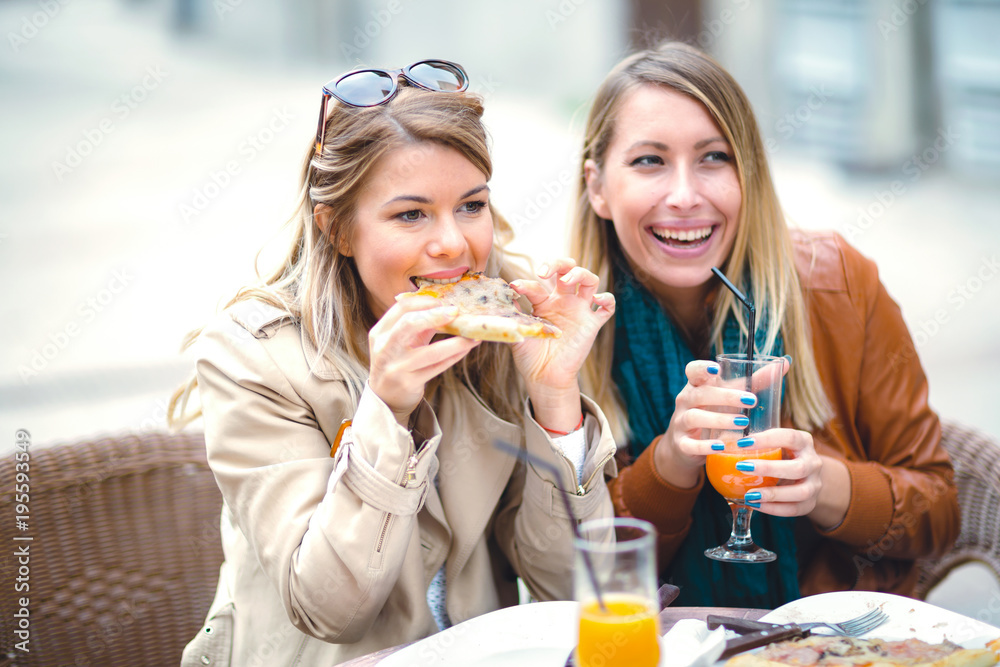 Portrait of two young women meating in cafe eating pizza outdoors,having fun together. Portrait of two young women meating in cafe eating pizza outdoors,having fun together.