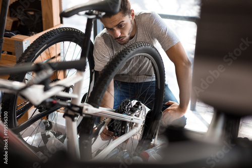 Mechanic assembling a bicycle in workshop