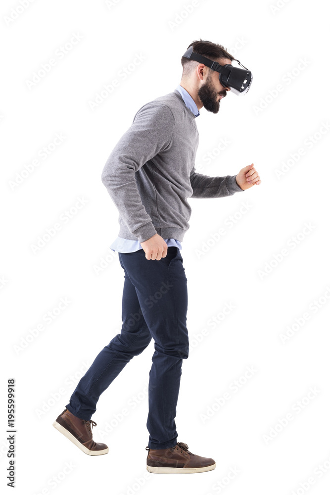 Side view of bearded man watching virtual reality glasses running and looking down. Full body isolated on white background. Side view of bearded man watching virtual reality glasses running and looking down. Full body isolated on white background.