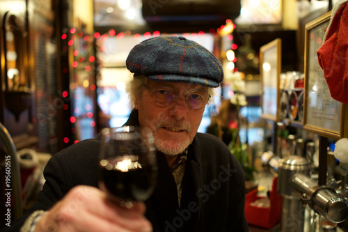 Canvas Print Mature Man in Harris Tweed Hat - holding glass of red wine, at bar