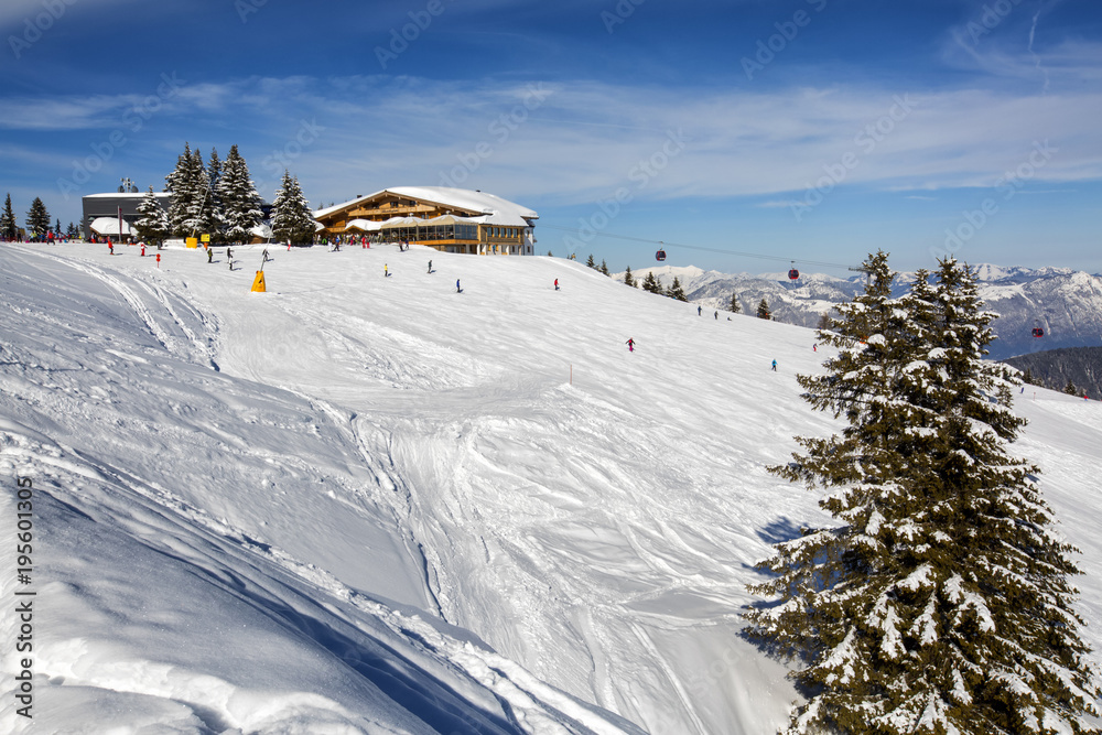 Panoramic view of ski slope in winter sunny day at the mountain ski resort of Alpbachtal, Wildschönau, Austria. People skiing down the hill.