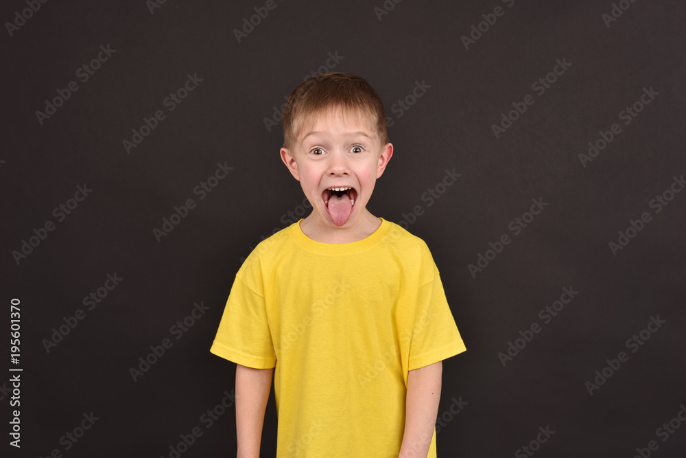 Emotional guy. Portrait of a boy in a T-shirt. Shooting in the studio. A young man on a black background. Emotional guy. Portrait of a boy in a T-shirt. Shooting in the studio. A young man on a black background.